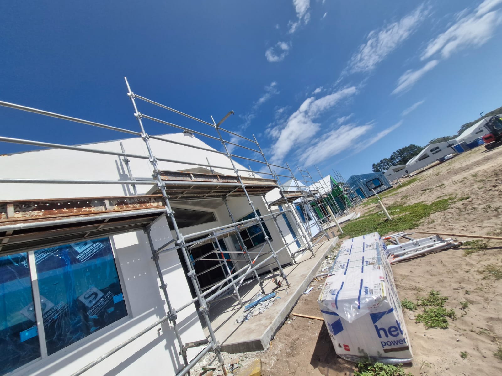 Front elevations with light render, protected windows and scaffolding